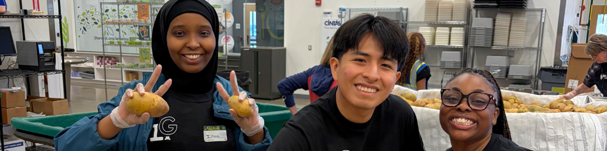 Students smile while packing potatoes at Second Harvest Heartland.