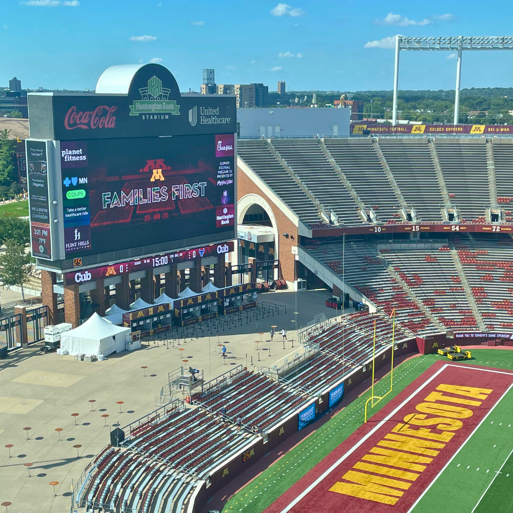 Huntington Bank Stadium field featuring the Families First logo on the jumbotron.