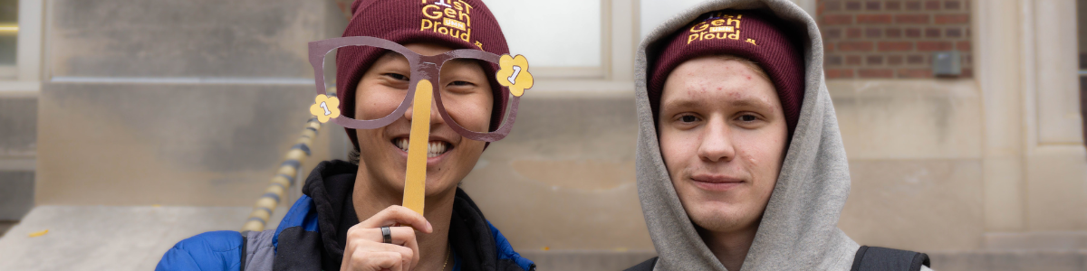Two students post with first-gen hats during First-Gen Celebration Week.
