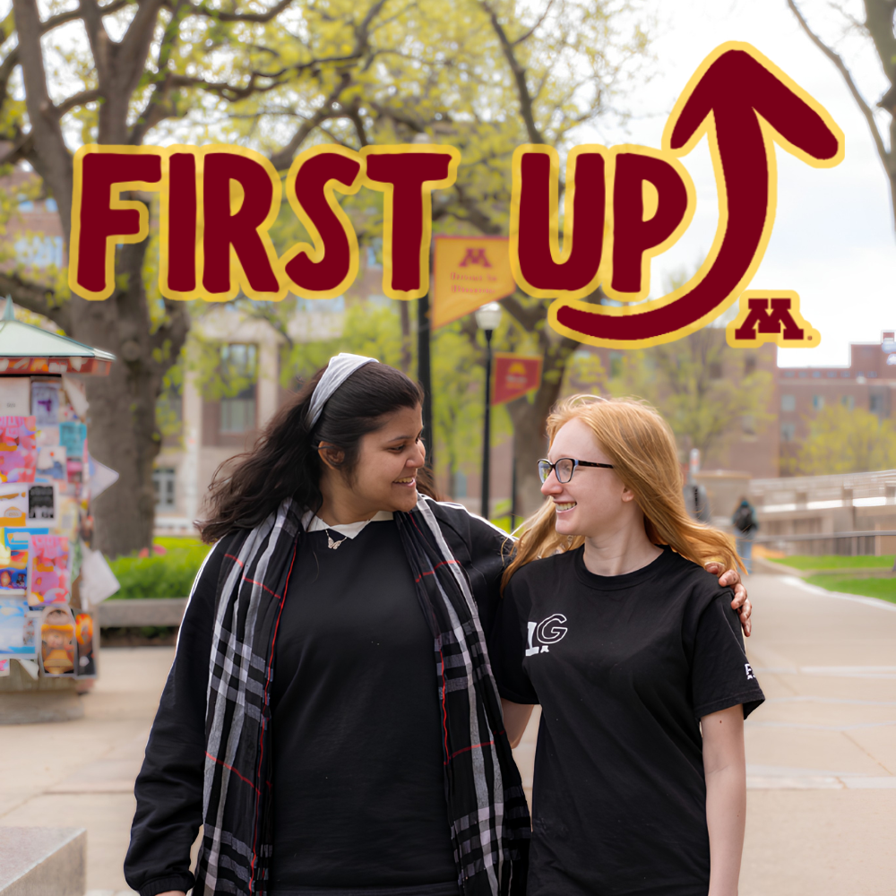 First Up promo image featuring 2 students walking and talking on the East Bank mall.